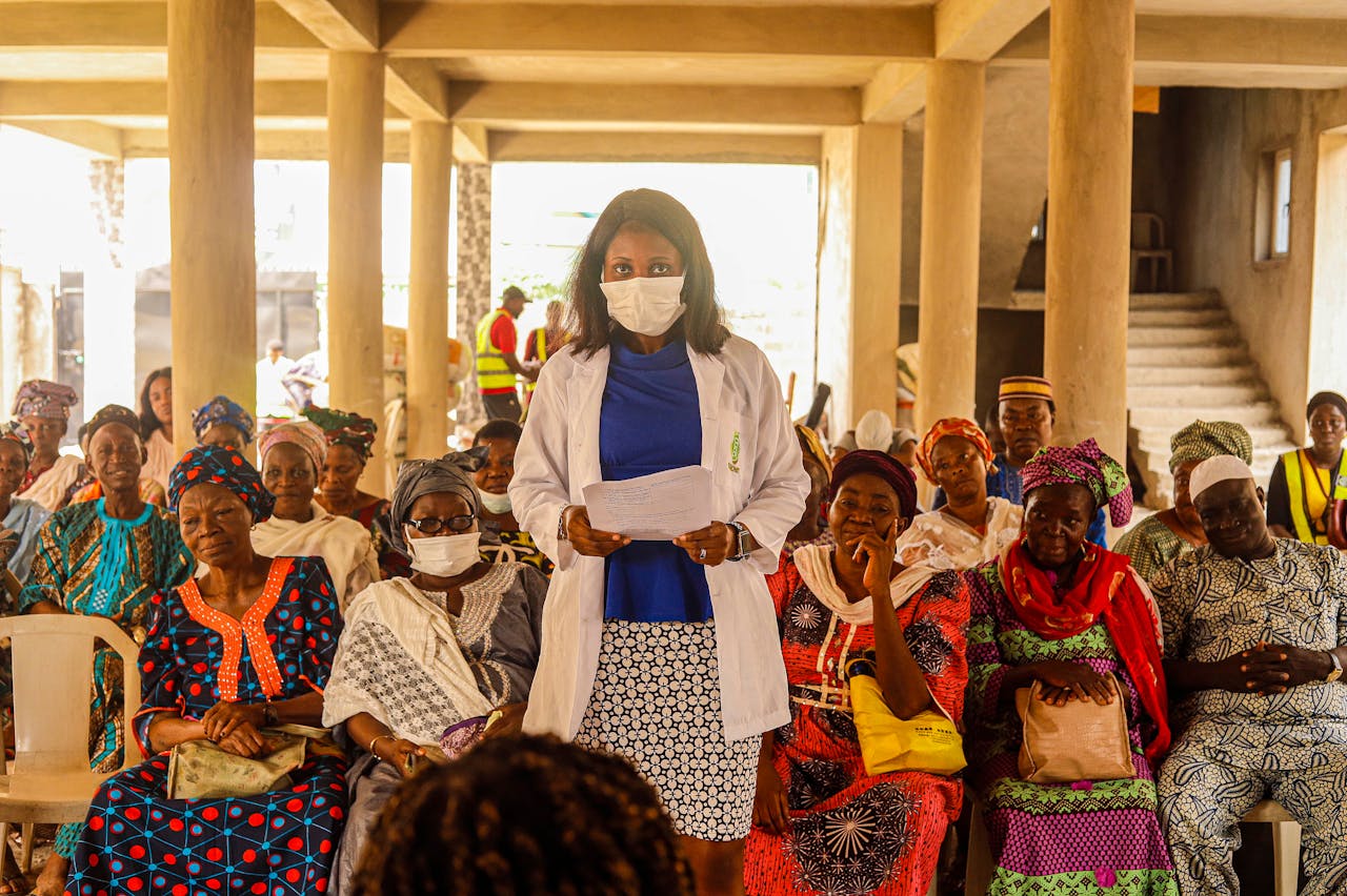 A female doctor giving a health lecture to a group of senior women indoors.